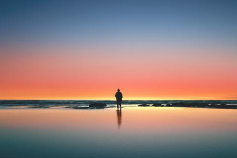 A man on a beach at sunset